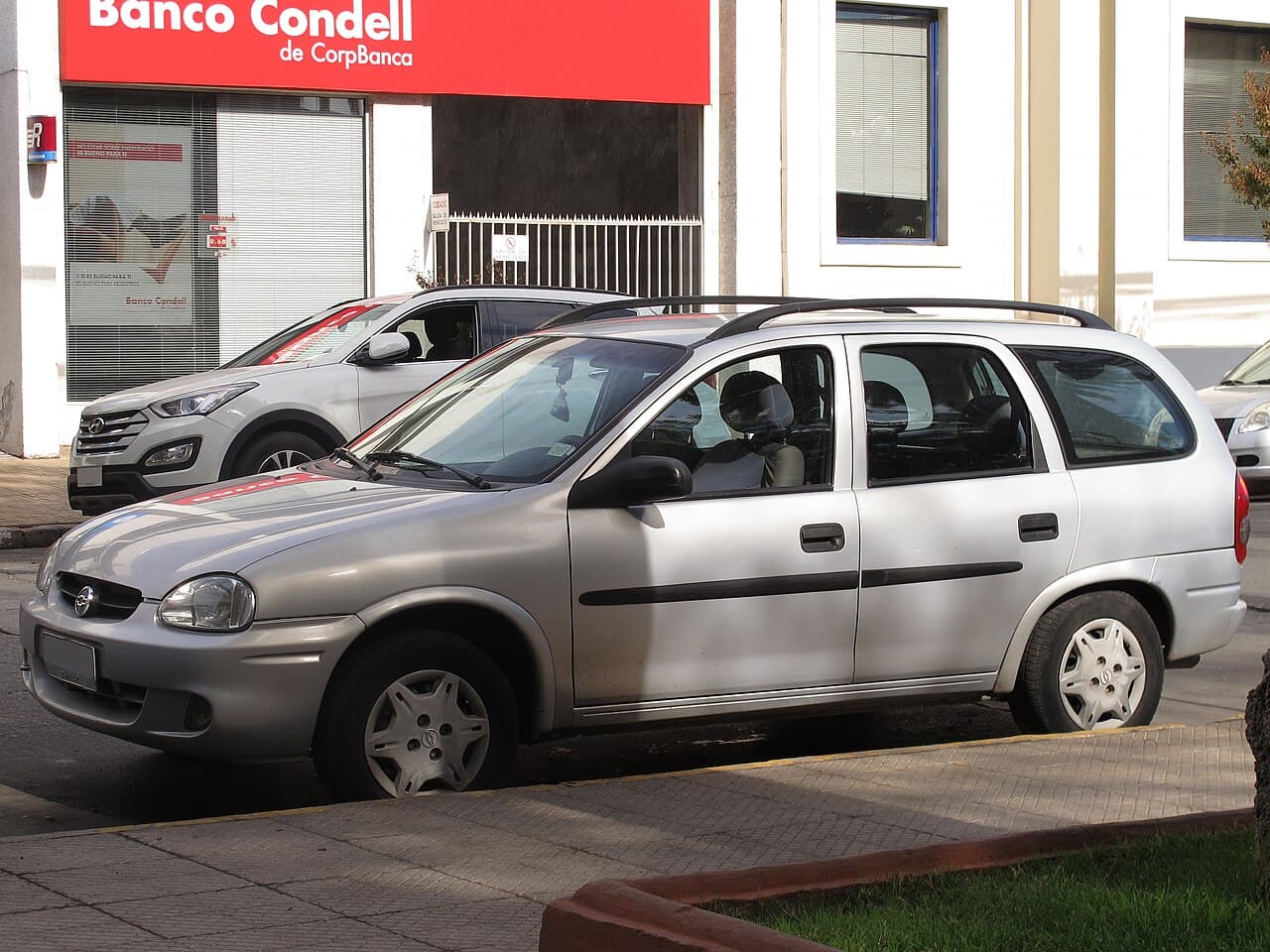 Corsa Wagon prata de cinco portas com longarinas de teto, vista de perfil dianteiro